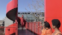 a group of people standing on a red spiral staircase