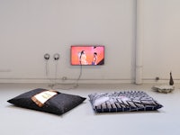 a room with two pillows and a tv on the floor