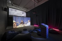 a room with people sitting on beanbags and watching a movie